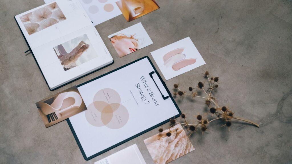 Materiały strategii marki i moodboard rozłożone na biurku podczas pracy nad brandingiem
