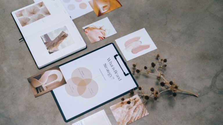 Materiały strategii marki i moodboard rozłożone na biurku podczas pracy nad brandingiem