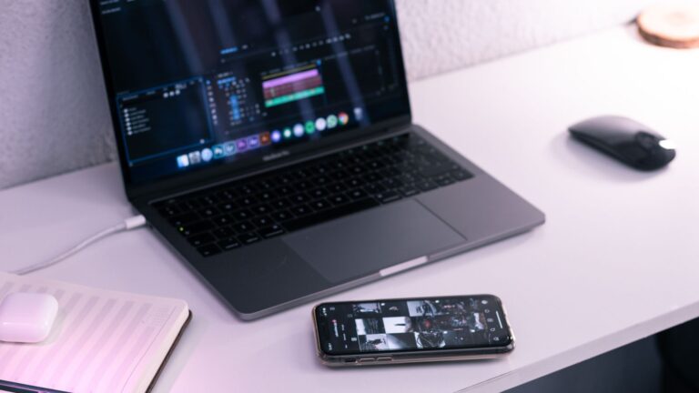 Laptop i smartfon na stanowisku pracy jako ilustracja obecności marki w kanałach cyfrowych